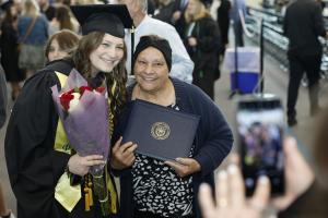 female graduate poses with older female