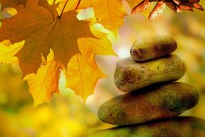 Stacked stones against autumn leaves.