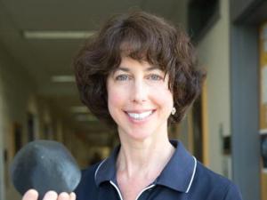 Professor Beth Ellen Clark holds a model of the asteroid Bennu.