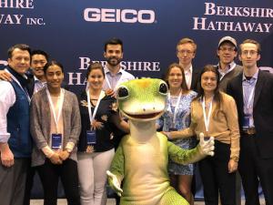 A group of people posing with the Geico gecko