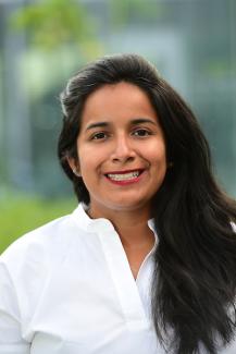 image of a smiling brown-skinned woman with long black hair and a white blouse