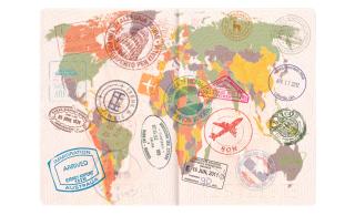 A colorful world map printed on the pages of a small booklet, like a passport, with multiple passport stamps all over the pages.