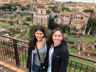 Two students standing in front of the Roman Forum in Italy