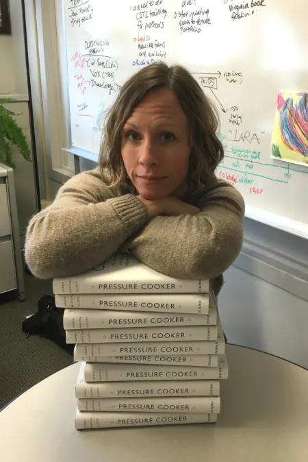 A woman leaning on a stack of books