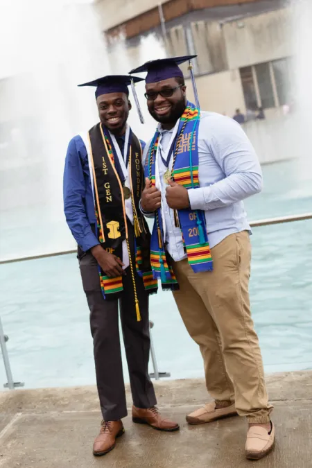 Two students pose in front of fountains