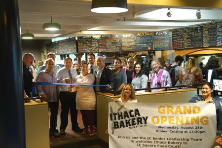 A group of people with a banner outside a food court location
