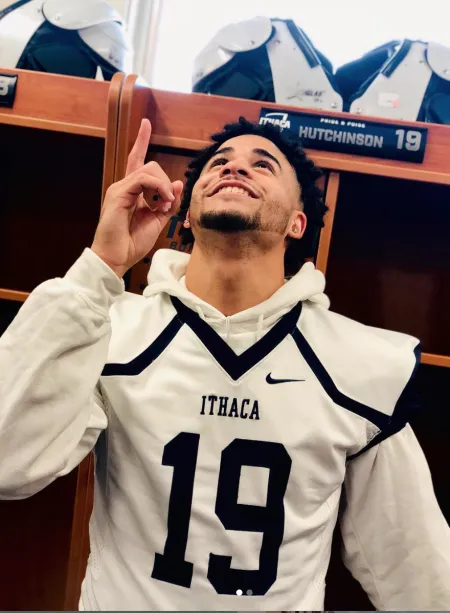 Young man in football jersey pointing towards the sky