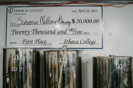A large check hanging above steel tanks