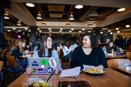 Two young women eating at a table