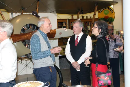 people mingling in front of an airplane
