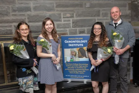 society inductees standing with flowers