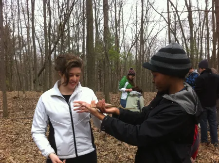 two people in the woods holding a snake