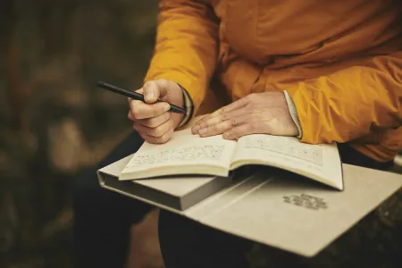person writing in journal
