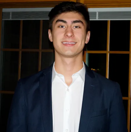 This is a photo of Justinian Michaels. Justinian is wearing a dark blue blazer with a white shirt underneath.