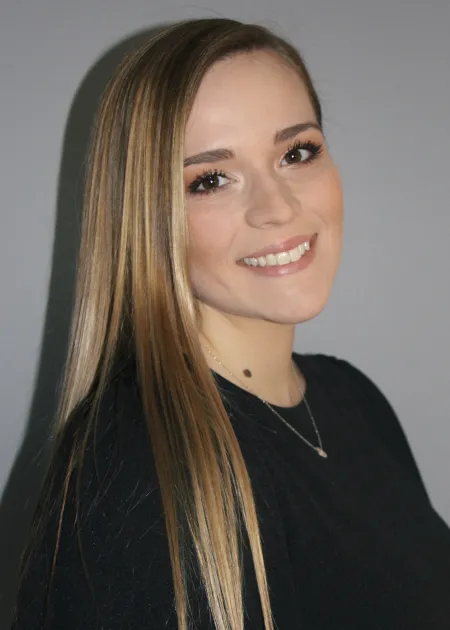 This is a photo of Kaitlyn Sevilla. Kaitlyn is wearing a long sleeve black shirt. The hair is long and draped over the shoulder.