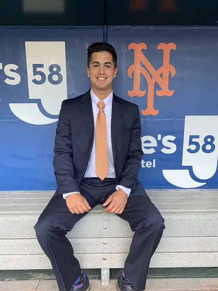 man in suit in baseball dugout