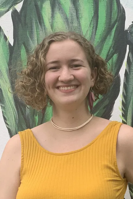 woman in front of flower mural