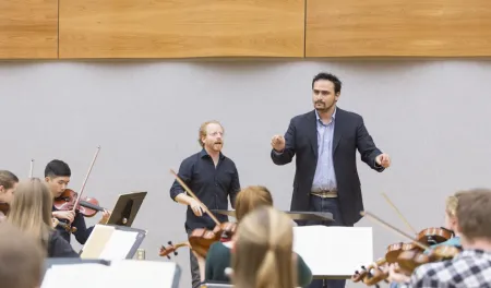 Graduate student conducting an orchestra