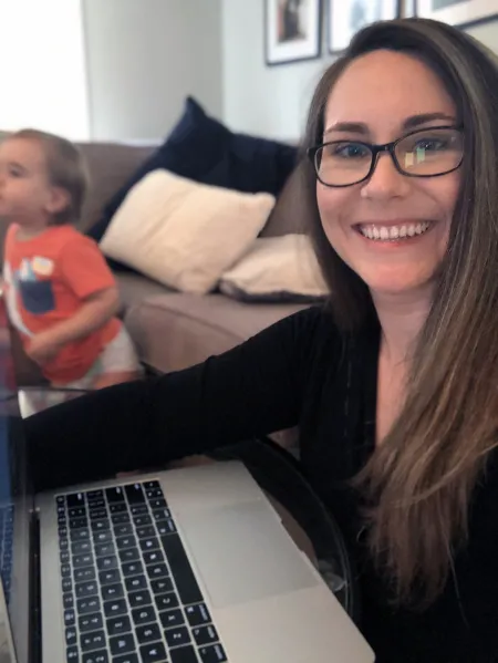 woman at computer with child in the background