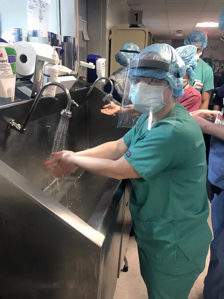 woman in ppe washing hands