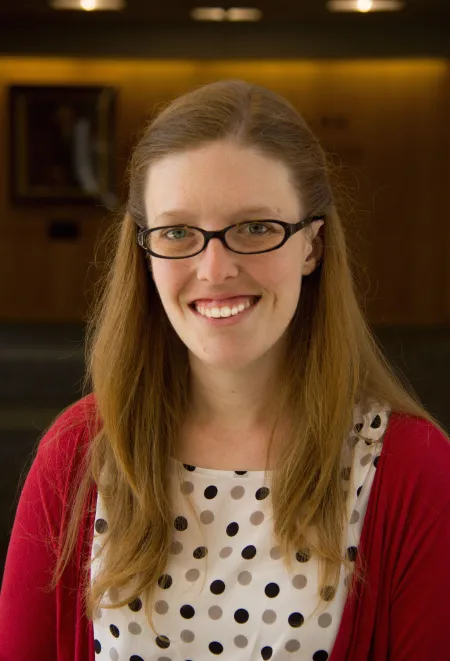 Headshot of woman wearing blazer and glasses