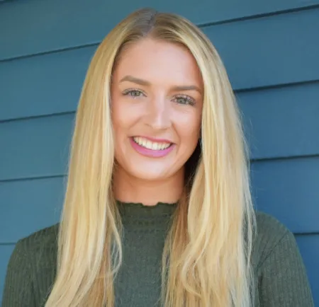 Gabby Picca standing in front of a wall