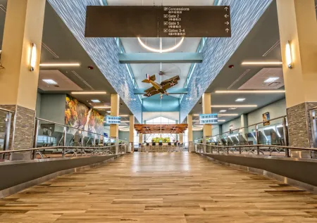 This is a picture of the inside of the Ithaca airport including a model airplane hanging from the ceiling