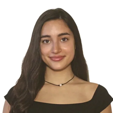 Isabella is looking at the camera, smiling. She is wearing a black blouse with a black necklace; her hair is parted to the side.