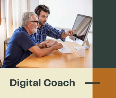 older man using a computer with a younger man pointing to monitor