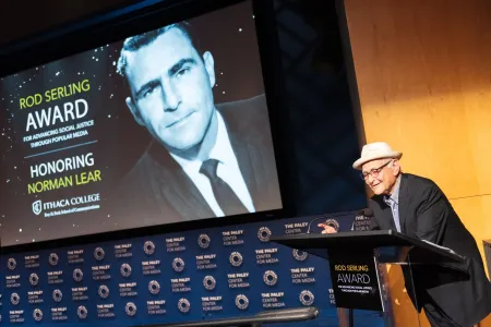 Man wearing hat at a podium.