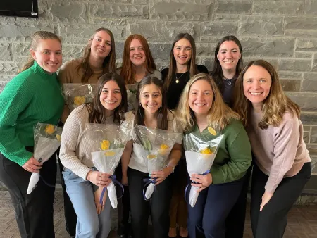 Bonnie Riley posing with eight graduate occupational therapy students after presenting research.
