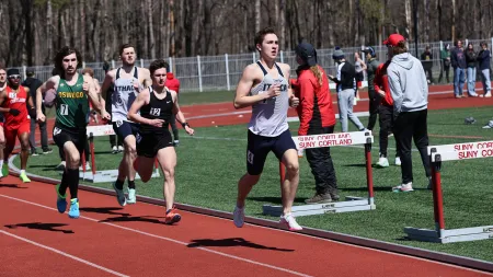 Male student-athlete running on a track.