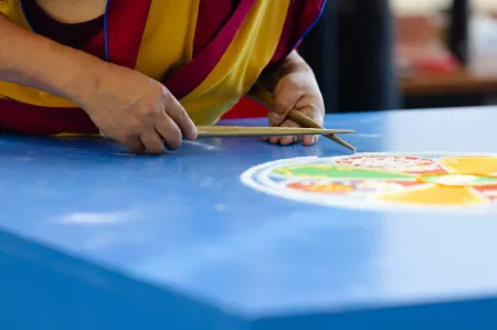 monk placing sand in the mandala