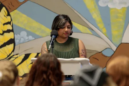 An author reads at a podium. 