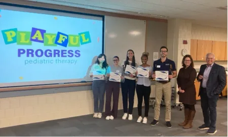 PT students and invited "sharks" stand in front of projection screen