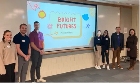 PT students and invited "sharks" stand in front of projection screen