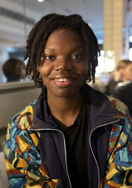 Caroline in IC dining hall wearing a multi-colored jacket