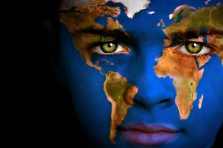 A close-up of a face with a world map painted on it. 