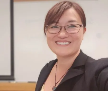Headshot of Lai Sze Tso. Lai Sze is wearing a black suit jacket and glasses.