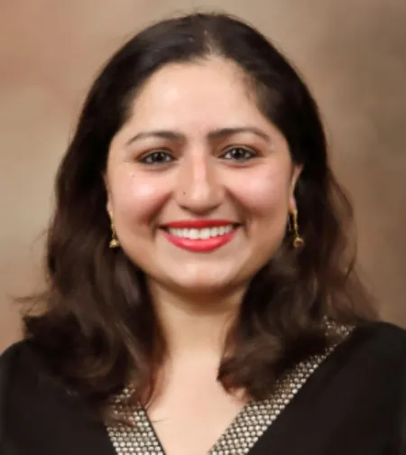 Headshot of Shehnaz Haqqani. Shehnaz is wearing a black top with silver accents.