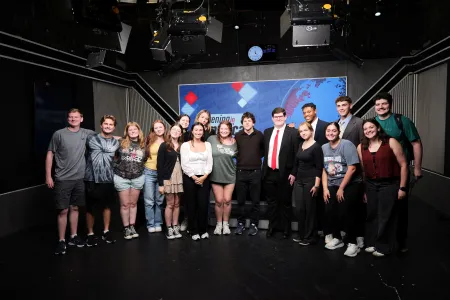 Students with Eisenberg in a television studio/classroom.