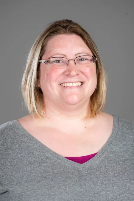 Headshot image of Laura Davis on grey background.