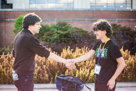 Eisenberg shakes hands with a student. 