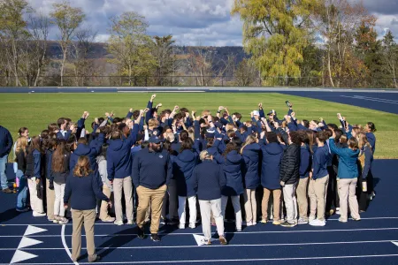 A crowd gather on the track.