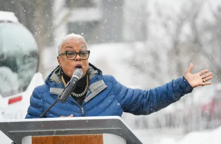 A woman speaks at a podium on a snowy day.