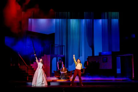 Students perform in a play onstage.