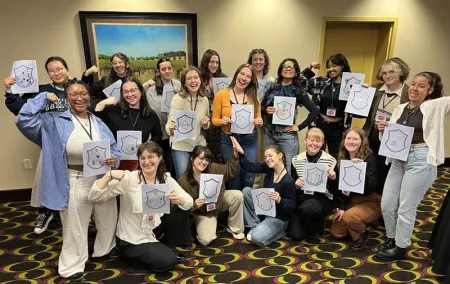 A group of students holding papers and posing for the camera.