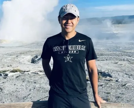man wearing cap standing in front of geysers