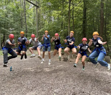 Grou8 students jumping in the air and wearing IC gear