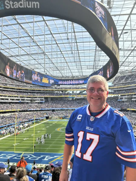 A man in a football stadium wears a Buffalo Bills jersey.